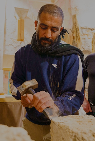 An artisan chiselling a stone