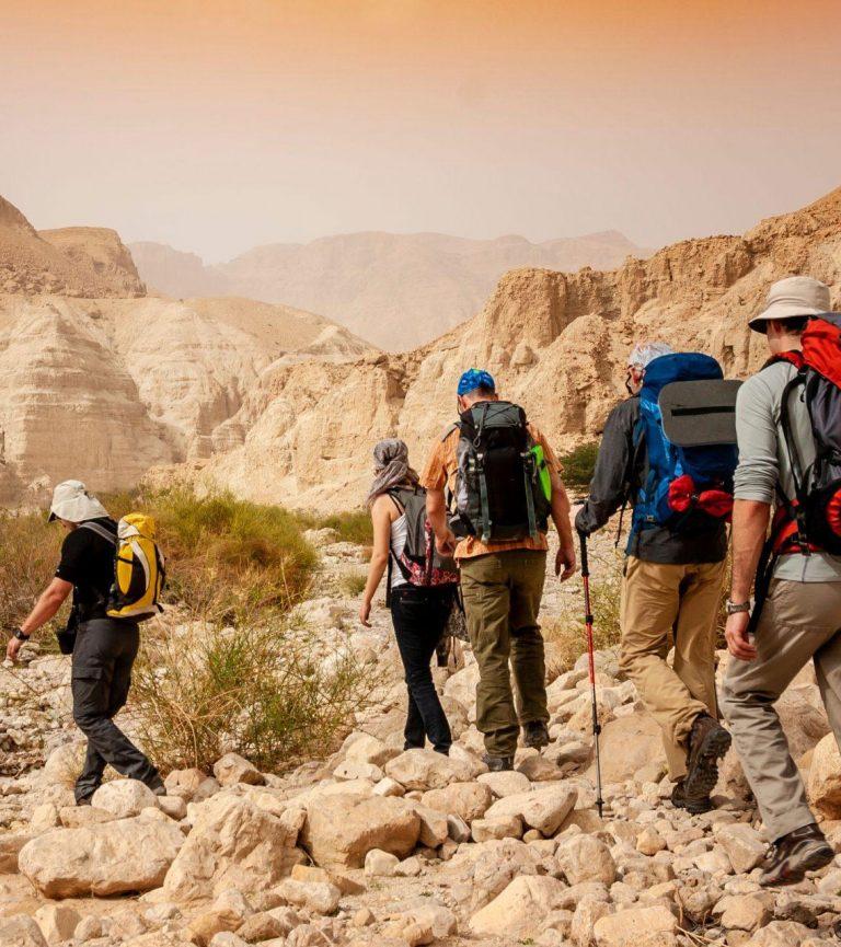 Several hikers walking through a rocky landscape in Israel.