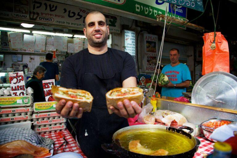 A smiling vendor in the Carmel Market in Tel Aviv selling Burika.