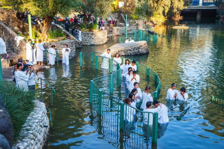 Pilgrims baptizing in the Jordan River at the Yardenit Baptismal site in the Galilee region of northern Israel.