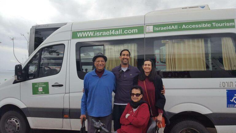 A group of travelers and a tour guide standing in front of an Israel4All accessible tourism van.